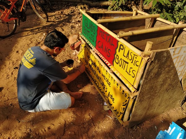 A man painting a trash bin